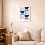 北欧ミニマルなリビング空間に飾られた、ブルーの半円モチーフによるジオメトリック抽象アート（A3サイズ相当）。