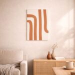 北欧ミニマルなリビング空間に飾られた、テラコッタカラーのカーブライン抽象アート（A3サイズ相当）。