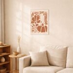 北欧ミニマルなリビング空間に飾られた、ブラウンフォルムのボタニカルコンポジション抽象アート（A3サイズ相当）。