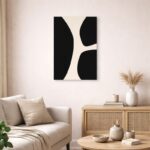 北欧ミニマルなリビング空間に飾られた、ブラックとベージュの有機カーブ抽象アート（A3サイズ相当）。