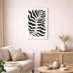 北欧ミニマルなリビング空間に飾られた、ブラックラインのボタニカルリーフ抽象アート（A3サイズ相当）。