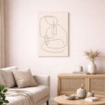北欧ミニマルなリビング空間に飾られた、ブラックラインのソフトジオメトリ抽象アート（A3サイズ相当）。