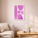 北欧ミニマルなリビング空間に飾られた、ピンクパープルのジオメトリック抽象アート（A3サイズ相当）。