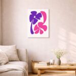 北欧ミニマルなリビング空間に飾られた、パープルとピンクのフラワーフォルムで描かれた北欧ミニマル 抽象アート（A3サイズ相当）。