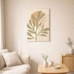 北欧ミニマルなリビング空間に飾られた、オリーブリーフと幾何フォルムのボタニカル抽象アート（A3サイズ相当）。