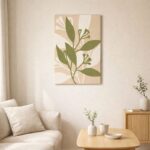 北欧ミニマルなリビング空間に飾られた、オリーブグリーンのリーフラインによるボタニカル抽象アート（A3サイズ相当）。