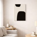 北欧ミニマルなリビング空間に飾られた、有機的ブラックフォルムの抽象アート（A3サイズ相当）。